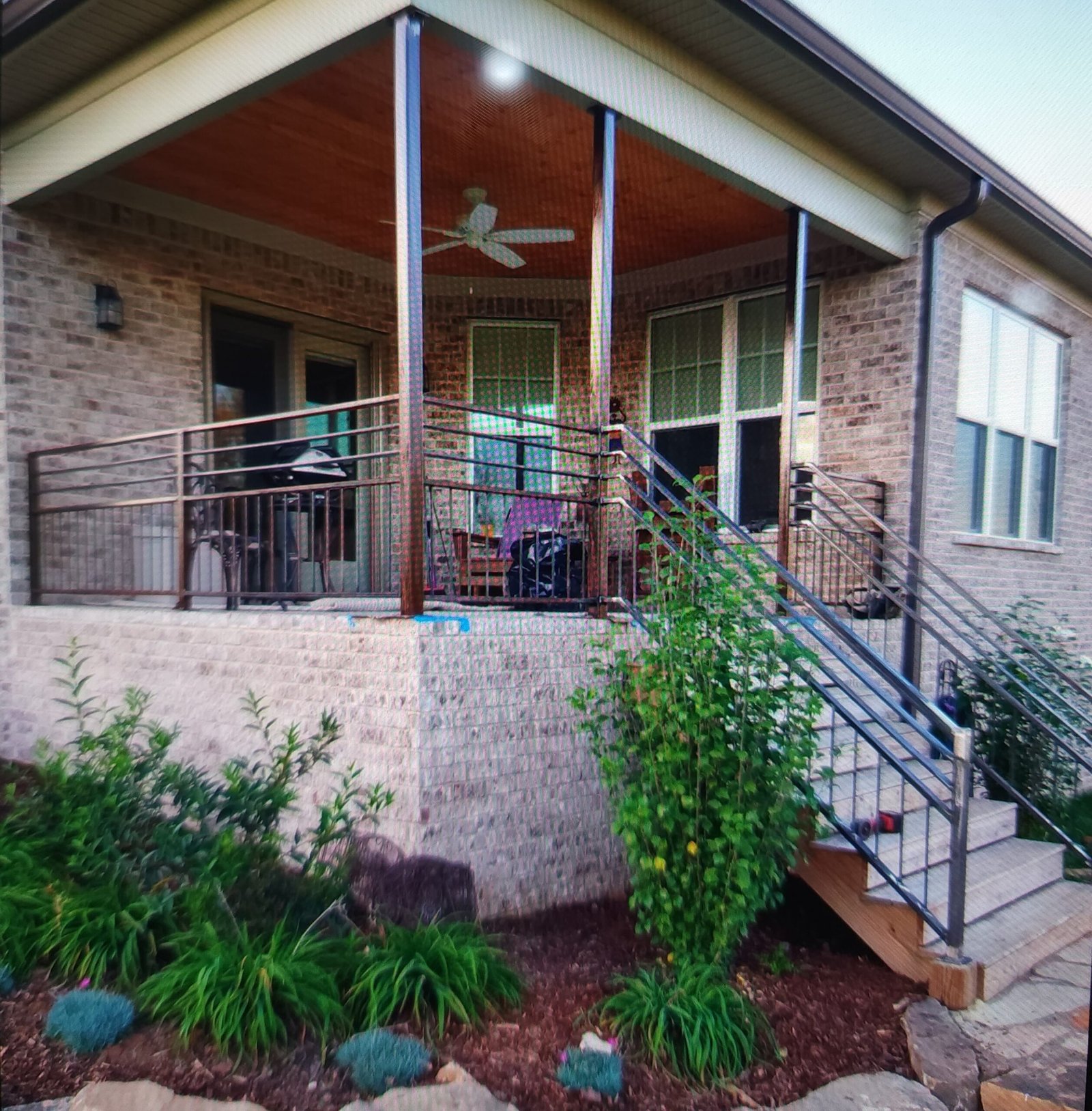 Covered porch with custom metal railing and wood accents in Middle Tennessee