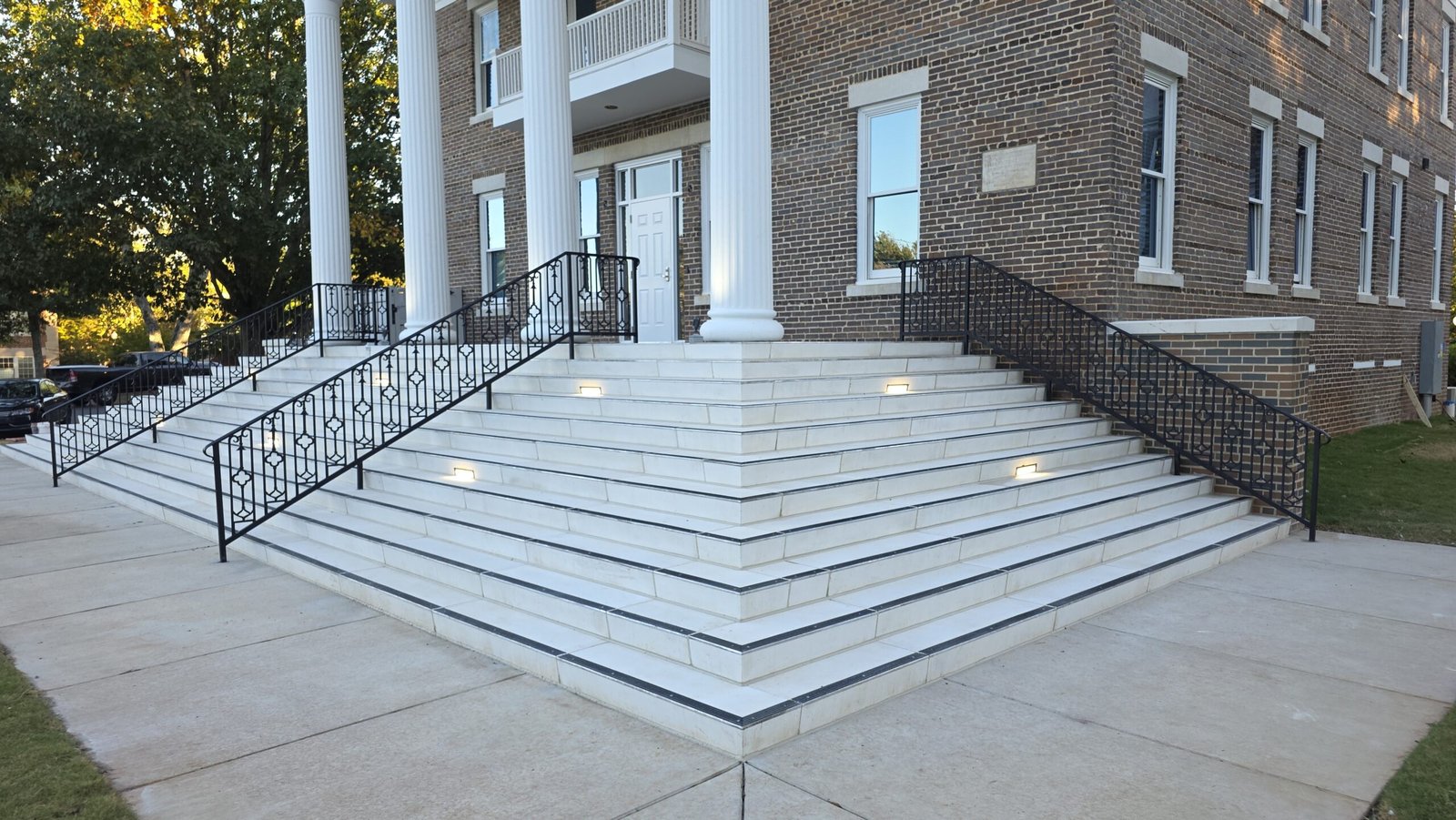 Curved marble entrance steps with custom ornamental iron railings in Franklin TN