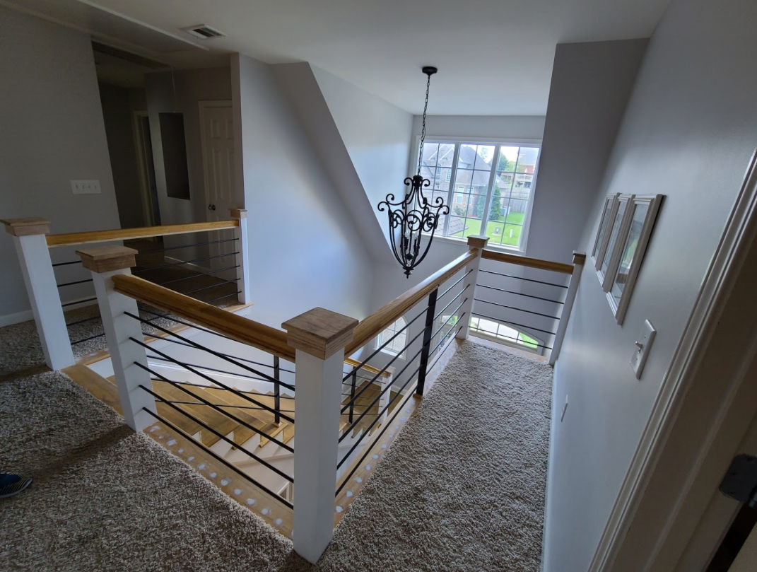 Custom wood and cable railing on an upstairs landing fabricated in Middle Tennessee