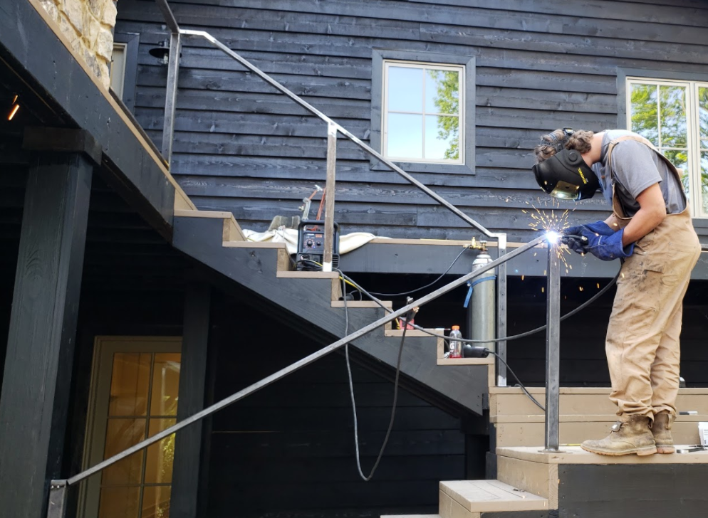 Mobile welding in progress as a 3D Custom Welding fabricator welds a custom steel railing on site